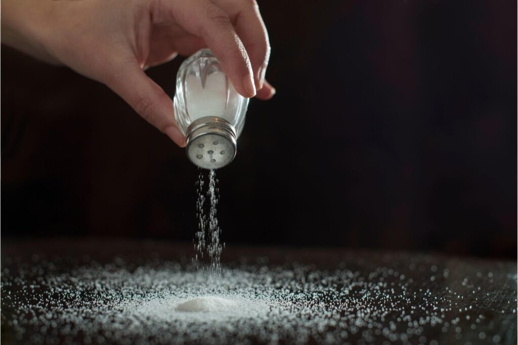 Sprinkling-Salt-on-Table-Concept