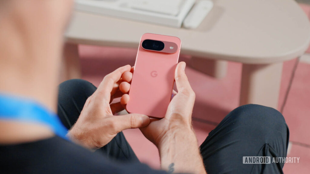 Google-Pixel-9-in-Peony-in-a-mans-hands-as-he-examines-the-back-of-the-device